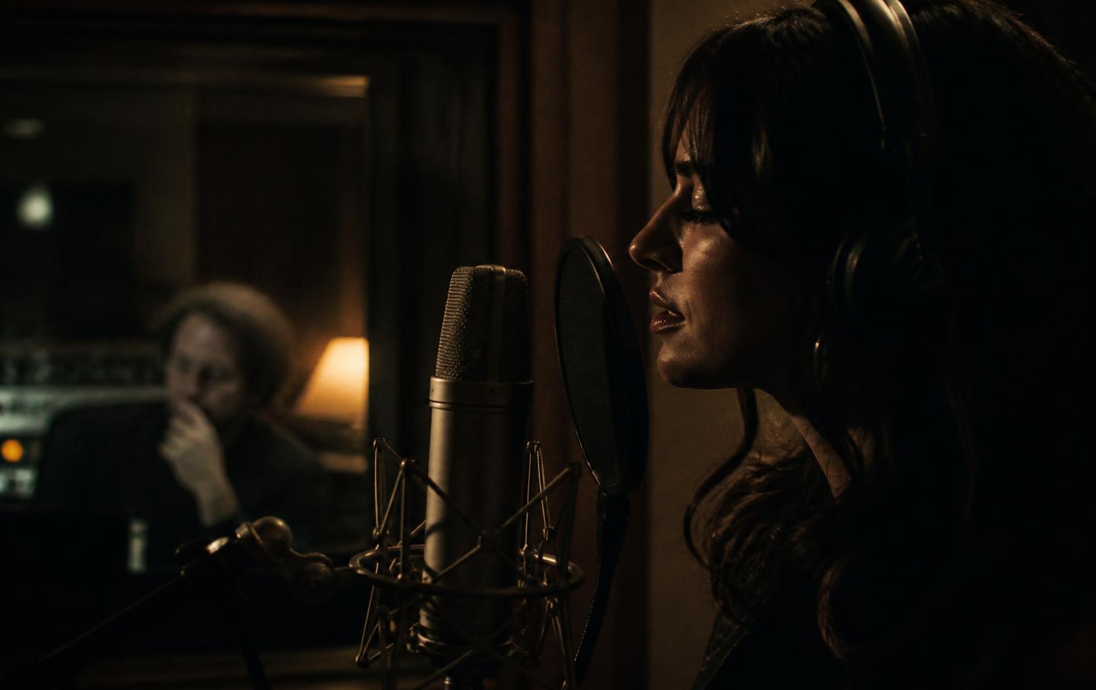 Vocalist recording with a producer in an intimate studio